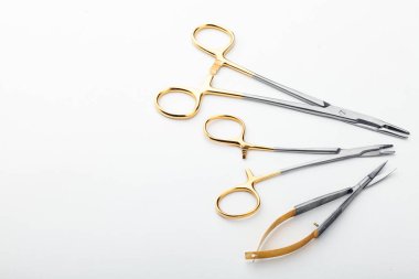 Çelik cerrahi aletler ve laboratuvar ekipmanları beyaz arka planda izole edilmiş. Profesyonel klinik aletleri. Tıbbi, cerrahi, ambulans ve veteriner konsepti. Yumuşak seçici odaklı yakın plan