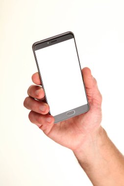 İnsan eli, avucunda boş bir krom ekran olan modern bir akıllı telefonu tutar. Teknoloji ve reklam kavramı. Ayrıntılı yakın çekim stüdyo çekimi soyut beyaz arka planda izole