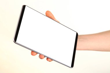 İnsan eli, avucunda boş bir krom ekran olan modern bir akıllı telefonu tutar. Teknoloji ve reklam kavramı. Ayrıntılı yakın çekim stüdyo çekimi soyut beyaz arka planda izole