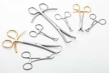 Çelik cerrahi aletler ve laboratuvar ekipmanları beyaz arka planda izole edilmiş. Profesyonel klinik aletleri. Tıbbi, cerrahi, ambulans ve veteriner konsepti. Yumuşak seçici odaklı yakın plan