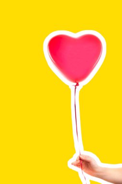 Kadın eli kırmızı kauçuk, şişme kalp şeklinde balon tutuyor. Aşk, ilişki, sevgililer günü ve doğum günü kutlaması konsepti. Boş kopya alanı olan dergi tarzı moda kolajı
