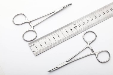 Çelik cerrahi aletler ve laboratuvar ekipmanları beyaz arka planda izole edilmiş. Profesyonel klinik aletleri. Tıbbi, cerrahi, ambulans ve veteriner konsepti. Yumuşak seçici odaklı yakın plan