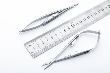 Çelik cerrahi aletler ve laboratuvar ekipmanları beyaz arka planda izole edilmiş. Profesyonel klinik aletleri. Tıbbi, cerrahi, ambulans ve veteriner konsepti. Yumuşak seçici odaklı yakın plan