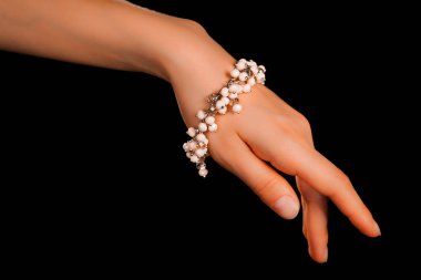 Güzel bir el yapımı mücevher bileziği. Renkli parlak boncuklar ve nötr manikürlü gevşek bir kadın bileği. Moda ve el işi aksesuarları. Yumuşak seçici odaklı yakın plan