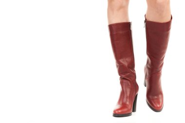Bayan giysi ayakkabısı. Uzun ince dişinin bacakları yüksek topuklu uzun çizmeler giyer. Fotokopi alanı olan moda modeli. Klasik ve günlük kıyafet konsepti. Ayrıntılı yakın çekim stüdyo çekimi beyaz arkaplanda izole edildi