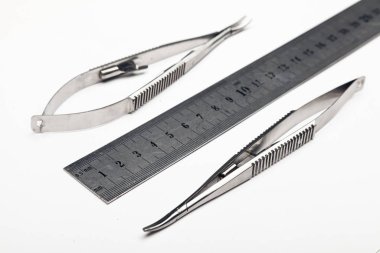 Çelik cerrahi aletler ve laboratuvar ekipmanları beyaz arka planda izole edilmiş. Profesyonel klinik aletleri. Tıbbi, cerrahi, ambulans ve veteriner konsepti. Yumuşak seçici odaklı yakın plan