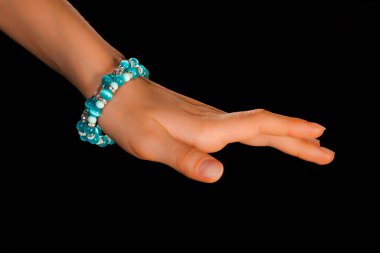 Güzel bir el yapımı mücevher bileziği. Renkli parlak boncuklar ve nötr manikürlü gevşek bir kadın bileği. Moda ve el işi aksesuarları. Yumuşak seçici odaklı yakın plan