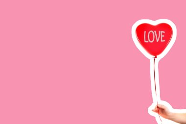 Kadın eli kırmızı kauçuk, şişme kalp şeklinde balon tutuyor. Aşk, ilişki, sevgililer günü ve doğum günü kutlaması konsepti. Boş kopya alanı olan dergi tarzı moda kolajı