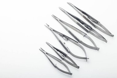 Çelik cerrahi aletler ve laboratuvar ekipmanları beyaz arka planda izole edilmiş. Profesyonel klinik aletleri. Tıbbi, cerrahi, ambulans ve veteriner konsepti. Yumuşak seçici odaklı yakın plan