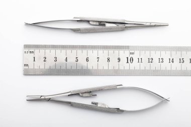 Çelik cerrahi aletler ve laboratuvar ekipmanları beyaz arka planda izole edilmiş. Profesyonel klinik aletleri. Tıbbi, cerrahi, ambulans ve veteriner konsepti. Yumuşak seçici odaklı yakın plan