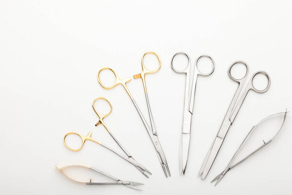 Steel surgical tools and laboratory equipment isolated on a white background. Professional clinic instruments. Medical, surgery, ambulance and veterinarian concept. Closeup with soft selective focus
