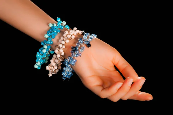 精美精致的手工珠宝手镯 色彩艳丽的珠子镶嵌在宽松的女性手腕上 配以中性的指甲 时装和手工艺品配件的概念 具有软性选择性焦点的闭锁 — 图库照片