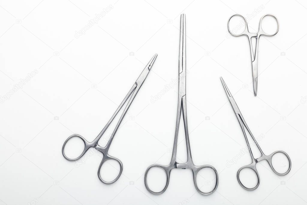 Steel surgical tools and laboratory equipment isolated on a white background. Professional clinic instruments. Medical, surgery, ambulance and veterinarian concept. Closeup with soft selective focus