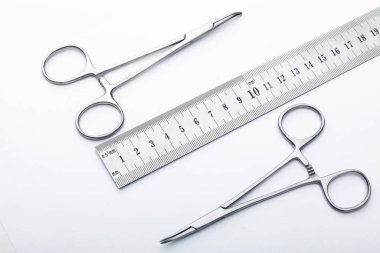 Çelik cerrahi aletler ve laboratuvar ekipmanları beyaz arka planda izole edilmiş. Profesyonel klinik aletleri. Tıbbi, cerrahi, ambulans ve veteriner konsepti. Yumuşak seçici odaklı yakın plan