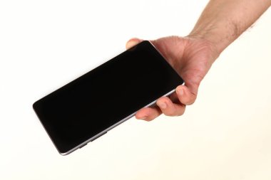İnsan eli, avucunda boş bir krom ekran olan modern bir akıllı telefonu tutar. Teknoloji ve reklam kavramı. Ayrıntılı yakın çekim stüdyo çekimi soyut beyaz arka planda izole