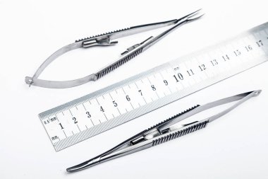 Çelik cerrahi aletler ve laboratuvar ekipmanları beyaz arka planda izole edilmiş. Profesyonel klinik aletleri. Tıbbi, cerrahi, ambulans ve veteriner konsepti. Yumuşak seçici odaklı yakın plan