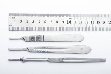 Çelik cerrahi aletler ve laboratuvar ekipmanları beyaz arka planda izole edilmiş. Profesyonel klinik aletleri. Tıbbi, cerrahi, ambulans ve veteriner konsepti. Yumuşak seçici odaklı yakın plan