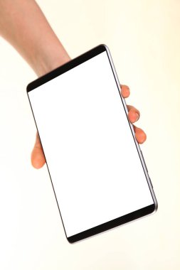 İnsan eli, avucunda boş bir krom ekran olan modern bir akıllı telefonu tutar. Teknoloji ve reklam kavramı. Ayrıntılı yakın çekim stüdyo çekimi soyut beyaz arka planda izole