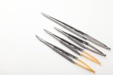 Çelik cerrahi aletler ve laboratuvar ekipmanları beyaz arka planda izole edilmiş. Profesyonel klinik aletleri. Tıbbi, cerrahi, ambulans ve veteriner konsepti. Yumuşak seçici odaklı yakın plan