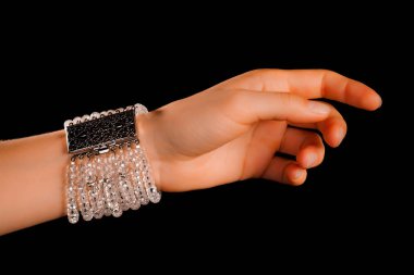 Güzel bir el yapımı mücevher bileziği. Renkli parlak boncuklar ve nötr manikürlü gevşek bir kadın bileği. Moda ve el işi aksesuarları. Yumuşak seçici odaklı yakın plan