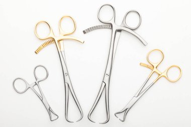 Çelik cerrahi aletler ve laboratuvar ekipmanları beyaz arka planda izole edilmiş. Profesyonel klinik aletleri. Tıbbi, cerrahi, ambulans ve veteriner konsepti. Yumuşak seçici odaklı yakın plan