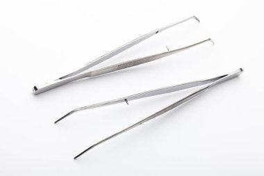 Çelik cerrahi aletler ve laboratuvar ekipmanları beyaz arka planda izole edilmiş. Profesyonel klinik aletleri. Tıbbi, cerrahi, ambulans ve veteriner konsepti. Yumuşak seçici odaklı yakın plan