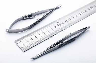 Çelik cerrahi aletler ve laboratuvar ekipmanları beyaz arka planda izole edilmiş. Profesyonel klinik aletleri. Tıbbi, cerrahi, ambulans ve veteriner konsepti. Yumuşak seçici odaklı yakın plan