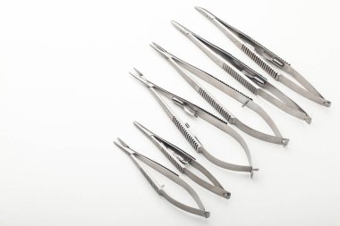 Çelik cerrahi aletler ve laboratuvar ekipmanları beyaz arka planda izole edilmiş. Profesyonel klinik aletleri. Tıbbi, cerrahi, ambulans ve veteriner konsepti. Yumuşak seçici odaklı yakın plan