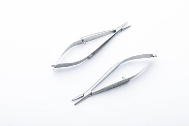 Çelik cerrahi aletler ve laboratuvar ekipmanları beyaz arka planda izole edilmiş. Profesyonel klinik aletleri. Tıbbi, cerrahi, ambulans ve veteriner konsepti. Yumuşak seçici odaklı yakın plan