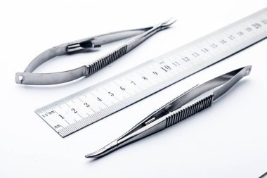 Çelik cerrahi aletler ve laboratuvar ekipmanları beyaz arka planda izole edilmiş. Profesyonel klinik aletleri. Tıbbi, cerrahi, ambulans ve veteriner konsepti. Yumuşak seçici odaklı yakın plan