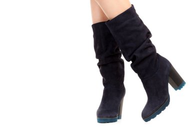 Bayan giysi ayakkabısı. Uzun ince dişinin bacakları yüksek topuklu uzun çizmeler giyer. Fotokopi alanı olan moda modeli. Klasik ve günlük kıyafet konsepti. Ayrıntılı yakın çekim stüdyo çekimi beyaz arkaplanda izole edildi