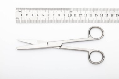 Çelik cerrahi aletler ve laboratuvar ekipmanları beyaz arka planda izole edilmiş. Profesyonel klinik aletleri. Tıbbi, cerrahi, ambulans ve veteriner konsepti. Yumuşak seçici odaklı yakın plan