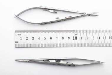 Çelik cerrahi aletler ve laboratuvar ekipmanları beyaz arka planda izole edilmiş. Profesyonel klinik aletleri. Tıbbi, cerrahi, ambulans ve veteriner konsepti. Yumuşak seçici odaklı yakın plan