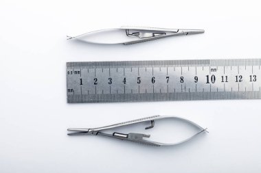 Çelik cerrahi aletler ve laboratuvar ekipmanları beyaz arka planda izole edilmiş. Profesyonel klinik aletleri. Tıbbi, cerrahi, ambulans ve veteriner konsepti. Yumuşak seçici odaklı yakın plan