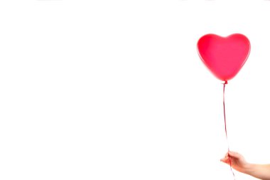 Kadın eli kırmızı kauçuk, şişme kalp şeklinde balon tutuyor. Aşk, ilişki, sevgililer günü ve doğum günü kutlaması konsepti. Stüdyo görüntüsü boş kopya alanı olan bulanık bir arkaplan üzerinde