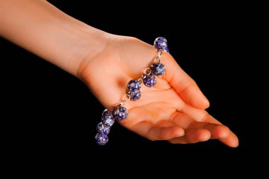 Güzel bir el yapımı mücevher bileziği. Renkli parlak boncuklar ve nötr manikürlü gevşek bir kadın bileği. Moda ve el işi aksesuarları. Yumuşak seçici odaklı yakın plan