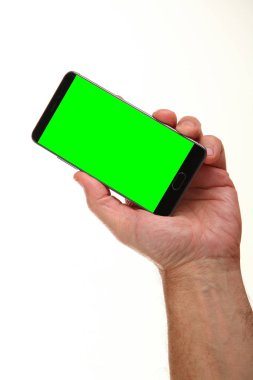 İnsan eli, avucunda boş bir krom ekran olan modern bir akıllı telefonu tutar. Teknoloji ve reklam kavramı. Ayrıntılı yakın çekim stüdyo çekimi soyut beyaz arka planda izole