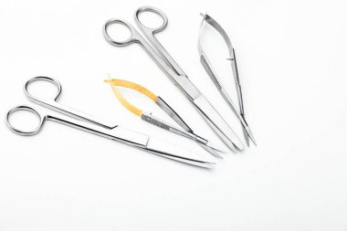 Çelik cerrahi aletler ve laboratuvar ekipmanları beyaz arka planda izole edilmiş. Profesyonel klinik aletleri. Tıbbi, cerrahi, ambulans ve veteriner konsepti. Yumuşak seçici odaklı yakın plan