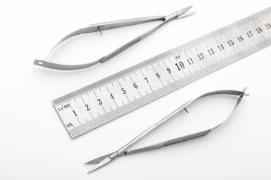 Çelik cerrahi aletler ve laboratuvar ekipmanları beyaz arka planda izole edilmiş. Profesyonel klinik aletleri. Tıbbi, cerrahi, ambulans ve veteriner konsepti. Yumuşak seçici odaklı yakın plan