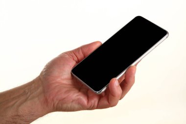 İnsan eli, avucunda boş bir krom ekran olan modern bir akıllı telefonu tutar. Teknoloji ve reklam kavramı. Ayrıntılı yakın çekim stüdyo çekimi soyut beyaz arka planda izole