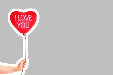 Kadın eli kırmızı kauçuk, şişme kalp şeklinde balon tutuyor. Aşk, ilişki, sevgililer günü ve doğum günü kutlaması konsepti. Boş kopya alanı olan dergi tarzı moda kolajı
