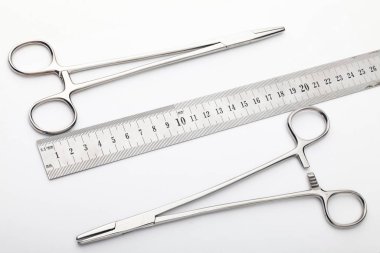 Çelik cerrahi aletler ve laboratuvar ekipmanları beyaz arka planda izole edilmiş. Profesyonel klinik aletleri. Tıbbi, cerrahi, ambulans ve veteriner konsepti. Yumuşak seçici odaklı yakın plan