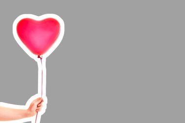 Kadın eli kırmızı kauçuk, şişme kalp şeklinde balon tutuyor. Aşk, ilişki, sevgililer günü ve doğum günü kutlaması konsepti. Boş kopya alanı olan dergi tarzı moda kolajı