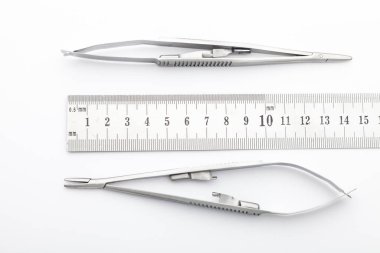 Çelik cerrahi aletler ve laboratuvar ekipmanları beyaz arka planda izole edilmiş. Profesyonel klinik aletleri. Tıbbi, cerrahi, ambulans ve veteriner konsepti. Yumuşak seçici odaklı yakın plan