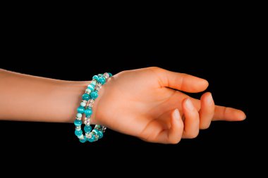 Güzel bir el yapımı mücevher bileziği. Renkli parlak boncuklar ve nötr manikürlü gevşek bir kadın bileği. Moda ve el işi aksesuarları. Yumuşak seçici odaklı yakın plan