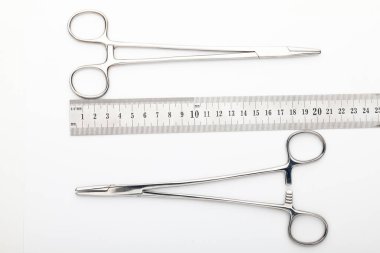 Çelik cerrahi aletler ve laboratuvar ekipmanları beyaz arka planda izole edilmiş. Profesyonel klinik aletleri. Tıbbi, cerrahi, ambulans ve veteriner konsepti. Yumuşak seçici odaklı yakın plan