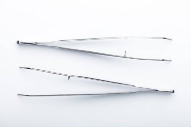 Çelik cerrahi aletler ve laboratuvar ekipmanları beyaz arka planda izole edilmiş. Profesyonel klinik aletleri. Tıbbi, cerrahi, ambulans ve veteriner konsepti. Yumuşak seçici odaklı yakın plan