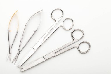 Çelik cerrahi aletler ve laboratuvar ekipmanları beyaz arka planda izole edilmiş. Profesyonel klinik aletleri. Tıbbi, cerrahi, ambulans ve veteriner konsepti. Yumuşak seçici odaklı yakın plan