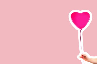 Kadın eli pembe kauçuk, şişme kalp şeklinde balon tutuyor. Aşk, ilişki, sevgililer günü ve doğum günü kutlaması konsepti. Boş kopya alanı olan dergi tarzı moda kolajı