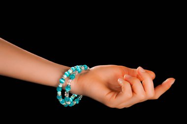 Güzel bir el yapımı mücevher bileziği. Renkli parlak boncuklar ve nötr manikürlü gevşek bir kadın bileği. Moda ve el işi aksesuarları. Yumuşak seçici odaklı yakın plan